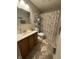 Neutral bathroom featuring a single sink vanity, a toilet, and a shower with a patterned curtain at 9415 Timber View Dr, Indianapolis, IN 46250