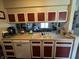 Kitchen with red and white cabinets, a sink, and a dishwasher, well-organized and functional at 9415 Timber View Dr, Indianapolis, IN 46250