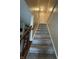 Carpeted stairway leading to the upper level, featuring a wooden handrail and a closet at the top at 9415 Timber View Dr, Indianapolis, IN 46250