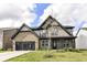 Charming two-story home with a brick and shingle exterior, black trim, and a well-manicured lawn at 9920 Deep Royal Way, Indianapolis, IN 46239