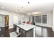 Open kitchen with central island, pendant lighting, stainless steel sink, and modern decor at 9920 Deep Royal Way, Indianapolis, IN 46239