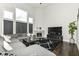 Spacious living room with high ceilings, large windows, a cozy fireplace, and a comfortable gray sectional at 9920 Deep Royal Way, Indianapolis, IN 46239
