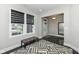Bright room with geometric rug, bench seating, and view of entryway with decorative glass door and dark wood floors at 9920 Deep Royal Way, Indianapolis, IN 46239