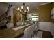 Elegant dining room with a large chandelier, dining table, seating for six, and staircase in the background at 10138 Backstretch Row, Fishers, IN 46040