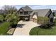 Beautiful home with manicured landscaping, flowering trees, and a curved driveway leading to the spacious two-car garage at 10138 Backstretch Row, Fishers, IN 46040