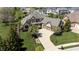 Aerial view showcasing the home's elegant exterior, manicured lawn, and inviting curved driveway to a two-car garage at 10138 Backstretch Row, Fishers, IN 46040