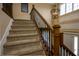 Carpeted staircase with decorative iron railings and natural light from the foyer at 10138 Backstretch Row, Fishers, IN 46040
