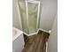 Compact bathroom with a corner shower, modern vanity, and hardwood flooring at 1019 E Jackson St, Shelbyville, IN 46176