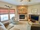 Cozy living room showcases a brick fireplace, plush armchairs, and natural light at 10190 Holly Berry Cir, Fishers, IN 46038