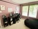 Bright, cheerful home office featuring two computer monitors, a black desk, and verdant window decorations at 10190 Holly Berry Cir, Fishers, IN 46038