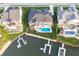 Stunning aerial view of a home with a private pool and lakeside docks, surrounded by lush greenery at 10590 Geist View Dr, Fishers, IN 46055