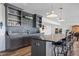Basement wet bar with gray cabinets, open shelving, modern fixtures and bar stool seating at 10590 Geist View Dr, Fishers, IN 46055