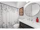 Well-lit bathroom with round mirror, floral shower curtain, and updated fixtures at 10590 Geist View Dr, Fishers, IN 46055