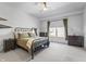 Bright bedroom featuring a large window, ceiling fan, and classic iron bed frame at 10590 Geist View Dr, Fishers, IN 46055