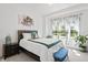 Light-filled bedroom with a large window and garden view, plus an artistic piano painting at 10590 Geist View Dr, Fishers, IN 46055