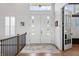Inviting foyer featuring double doors with windows, hardwood floors, and elegant lighting, creating a warm and welcoming ambiance at 10590 Geist View Dr, Fishers, IN 46055