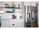 Kitchenette with decorative shelves, white cabinets, stainless steel refrigerator, and marble countertops at 10590 Geist View Dr, Fishers, IN 46055