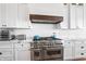 Modern kitchen featuring stainless steel oven and range, white cabinets, and marble countertops at 10590 Geist View Dr, Fishers, IN 46055