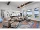 Spacious living room with leather furniture, wood beams, and many windows with views of the water at 10590 Geist View Dr, Fishers, IN 46055
