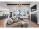 Bright living room featuring a fireplace, wood beams, modern lighting, and elegant leather furniture at 10590 Geist View Dr, Fishers, IN 46055