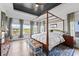 Bright bedroom with four-poster bed, wood flooring, and lake views at 10590 Geist View Dr, Fishers, IN 46055