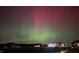 A mesmerizing display of the aurora borealis over a quiet neighborhood, illuminating houses in the dark at 10590 Geist View Dr, Fishers, IN 46055