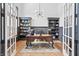 Stylish office with custom built-ins, hardwood floors, and ample natural light, creating an ideal workspace for productivity at 10590 Geist View Dr, Fishers, IN 46055