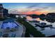 A beautifully lit pool and lakeside dock are displayed under a twilight sky, promising serene evenings at 10590 Geist View Dr, Fishers, IN 46055