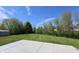 Wide backyard and concrete patio area surrounded by lush greenery and trees at 109 Buckthorne Ln, Mooresville, IN 46158
