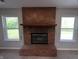 Cozy brick fireplace offering a focal point between two windows, creating a warm, inviting living space at 109 Buckthorne Ln, Mooresville, IN 46158