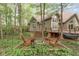 Serene backyard with a fire pit and surrounding Adirondack chairs, set amongst mature trees and verdant foliage at 10919 Running Tide Ct, Indianapolis, IN 46236