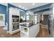 Kitchen with stainless steel double ovens and white cabinetry, along with an island and dark countertops at 10919 Running Tide Ct, Indianapolis, IN 46236