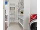 Bright laundry room with storage shelving units and a modern red washer and dryer set at 10919 Running Tide Ct, Indianapolis, IN 46236
