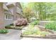 Landscaped side yard featuring decorative stone and mature plantings at 10919 Running Tide Ct, Indianapolis, IN 46236
