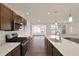 Modern kitchen with stainless steel appliances, a central island, and a view into the adjacent living space at 110 Maxim Ct, Cumberland, IN 46229