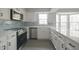 Bright kitchen features white cabinets, an island, stainless steel appliances, and a blue backsplash at 11212 Bayridge E Cir, Indianapolis, IN 46236