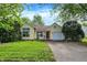 Charming yellow home with attached garage and well-manicured lawn and garden landscaping at 1127 Jody Ct, Greenwood, IN 46143