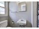 Bathroom featuring a white pedestal sink and toilet, complemented by a towel rack and a framed mirror at 12078 N 125 W, Alexandria, IN 46001