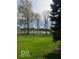 Expansive backyard with lush green grass and mature trees, offering privacy and scenic views of the water at 12353 Brean Way, Fishers, IN 46037