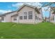 Exterior back of home showcasing well-maintained lawn and siding with ample windows for natural light at 12698 Whisper Way, Fishers, IN 46037