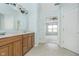 Bathroom with double vanity and tile flooring, leading to a bedroom with a ceiling fan at 12698 Whisper Way, Fishers, IN 46037