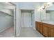 Well-lit bathroom featuring dual sinks, a large mirror, and a separate walk-in closet at 12698 Whisper Way, Fishers, IN 46037