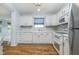 Modern kitchen featuring white cabinets, stainless steel appliances, and hardwood flooring at 12698 Whisper Way, Fishers, IN 46037