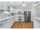 Contemporary kitchen with white cabinets, stainless steel appliances, and hardwood floors at 12698 Whisper Way, Fishers, IN 46037