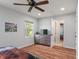 Bright bedroom features wood-look floors, ceiling fan, dresser, and a view into the hall at 1285 S 1100 E, Zionsville, IN 46077