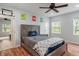 Well-lit bedroom with a ceiling fan, natural light, and modern decor and wood-look flooring at 1285 S 1100 E, Zionsville, IN 46077