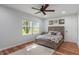 Charming bedroom featuring wood-look floors, a ceiling fan, and natural light from the windows at 1285 S 1100 E, Zionsville, IN 46077