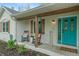Inviting front porch featuring a vibrant turquoise door, rocking chairs, and natural wood accents at 1285 S 1100 E, Zionsville, IN 46077