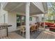 Covered outdoor dining area featuring a wooden table, chairs, grill, and convenient access to the home at 1285 S 1100 E, Zionsville, IN 46077