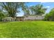 A spacious backyard with a covered patio area, complemented by green grass and mature trees at 150 Church St, Mooresville, IN 46158